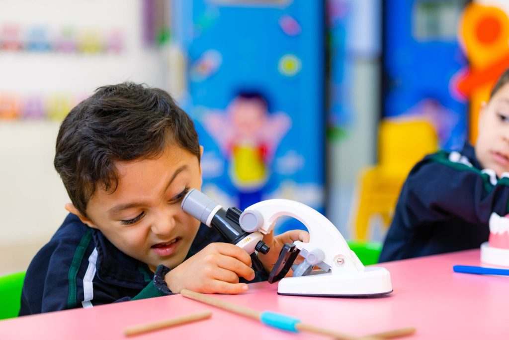 Young boy exploring science through a microscope