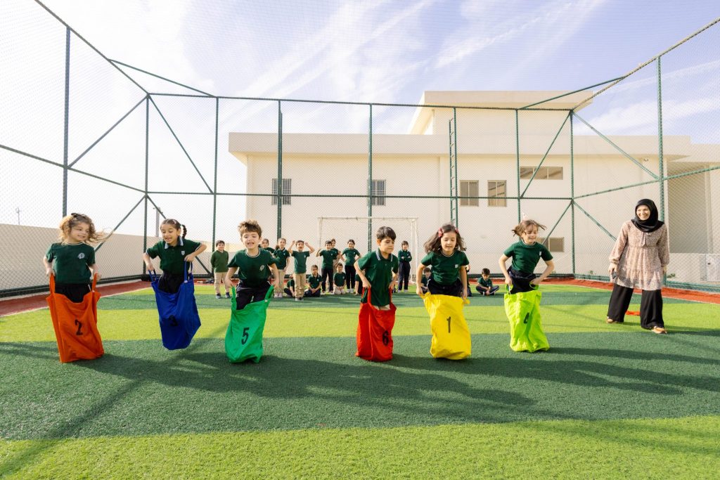 Primary students racing in a sack race during outdoor sports activity
